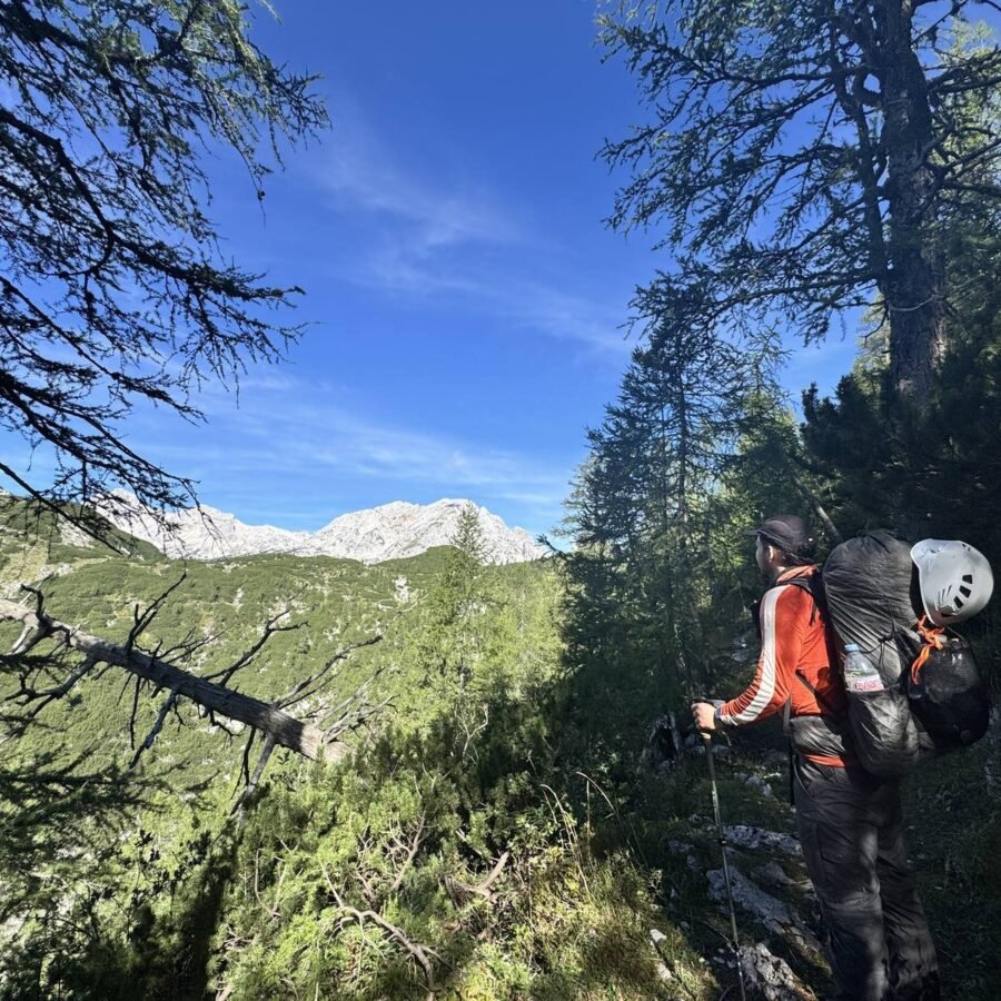 Wanderer mit Rucksack und Helm im Aufstieg von der Lipanca zur Waldgrenze