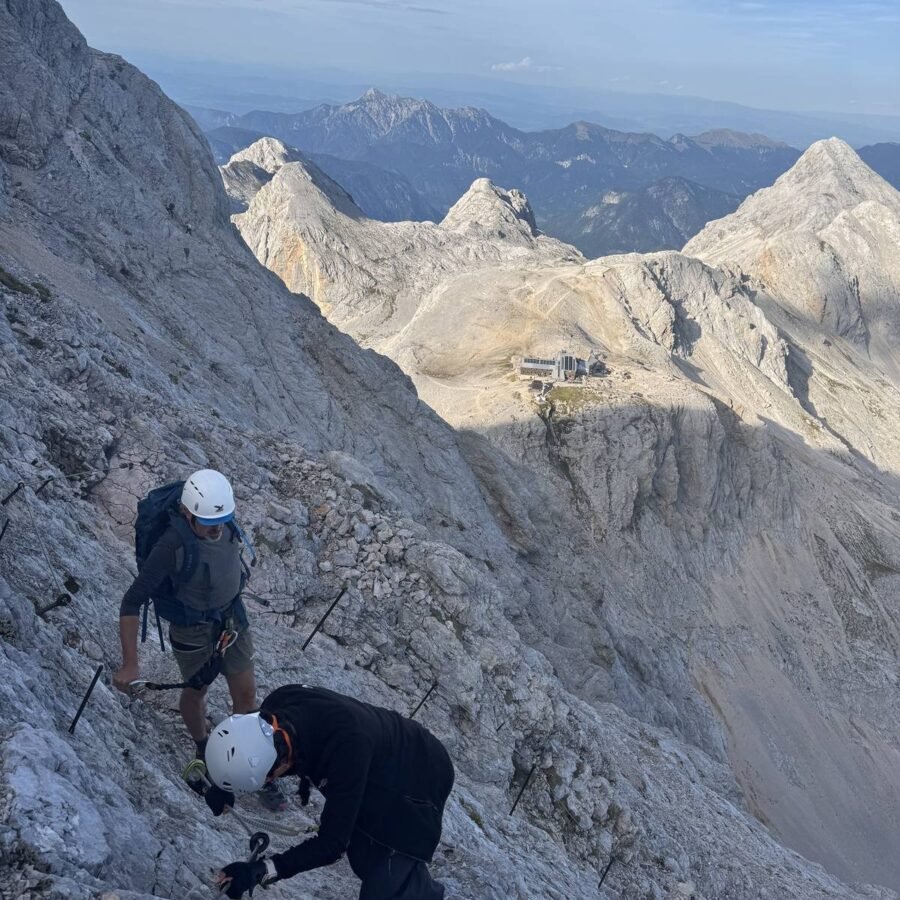 Zwei Bergsteiger mit Helm in einer gesicherten Passage am Triglav-Normalweg